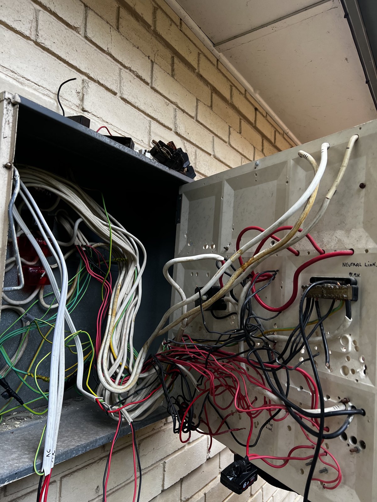 Old meter board with tangled mess of wires
